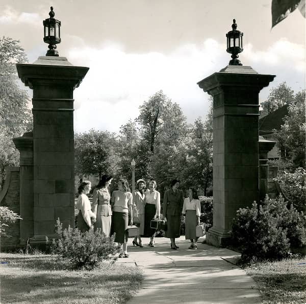 Historical image of a group of women walking through Rogers Gate.