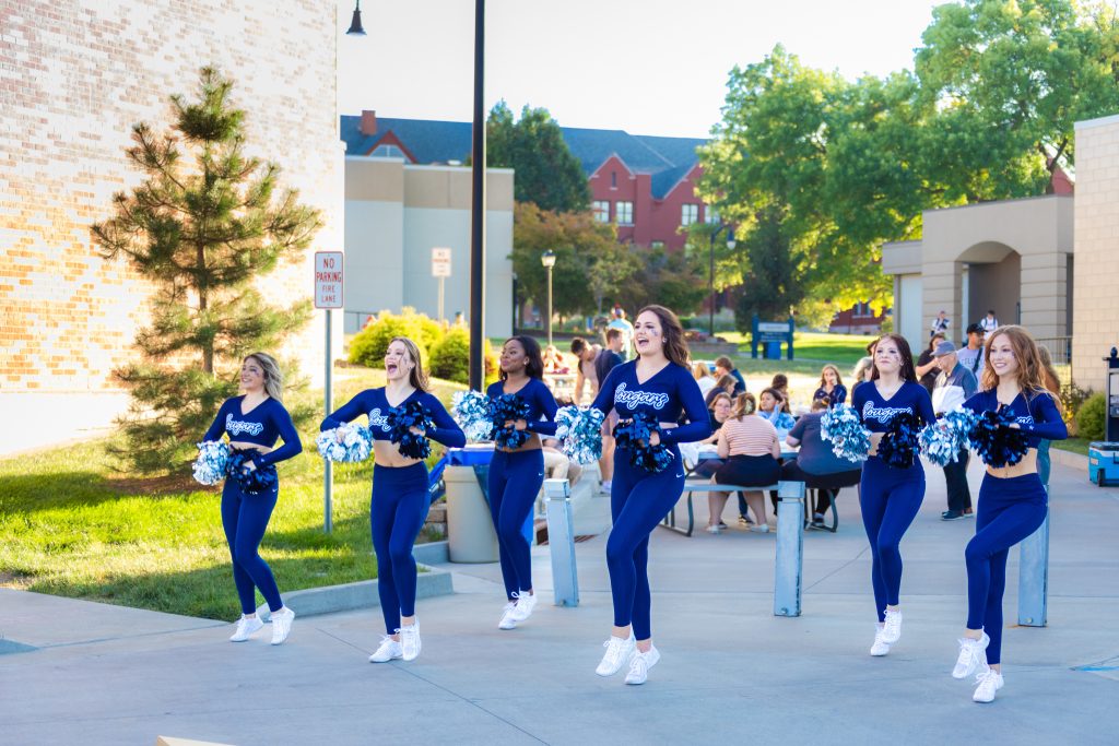 Columbia College pom squad members marching through main campus doing a routine.