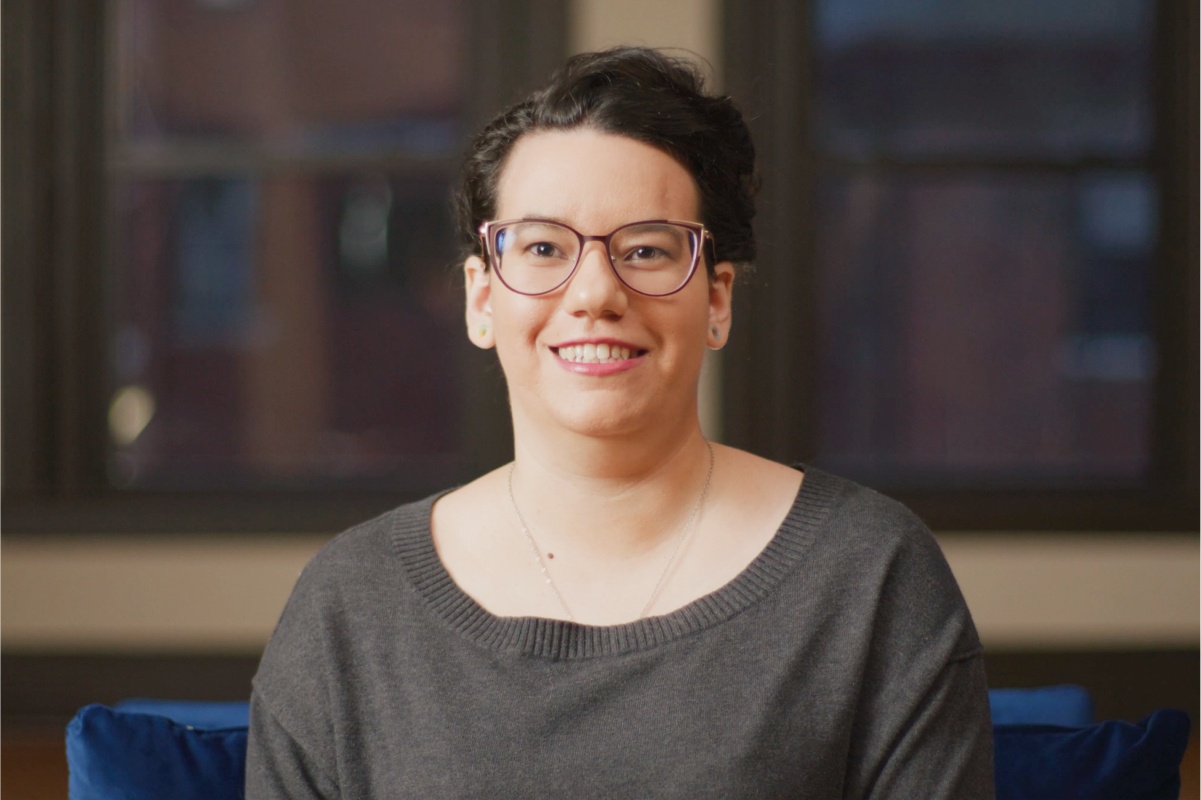 Image of a woman with glasses smiling