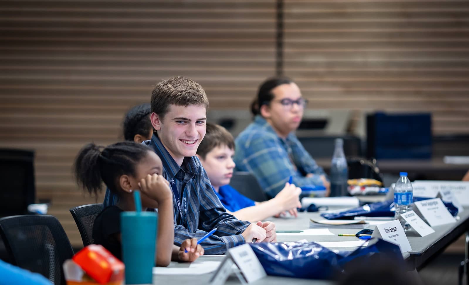 Four 2025 Voices of Leadership campers sitting at a table, engaged in the discussions.