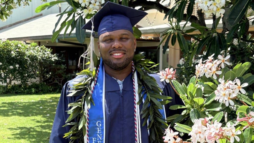 Jonathan Beck ’26 poses for a photo in his Columbia College cap, gown and ivy in Honolulu, Hawaii.
