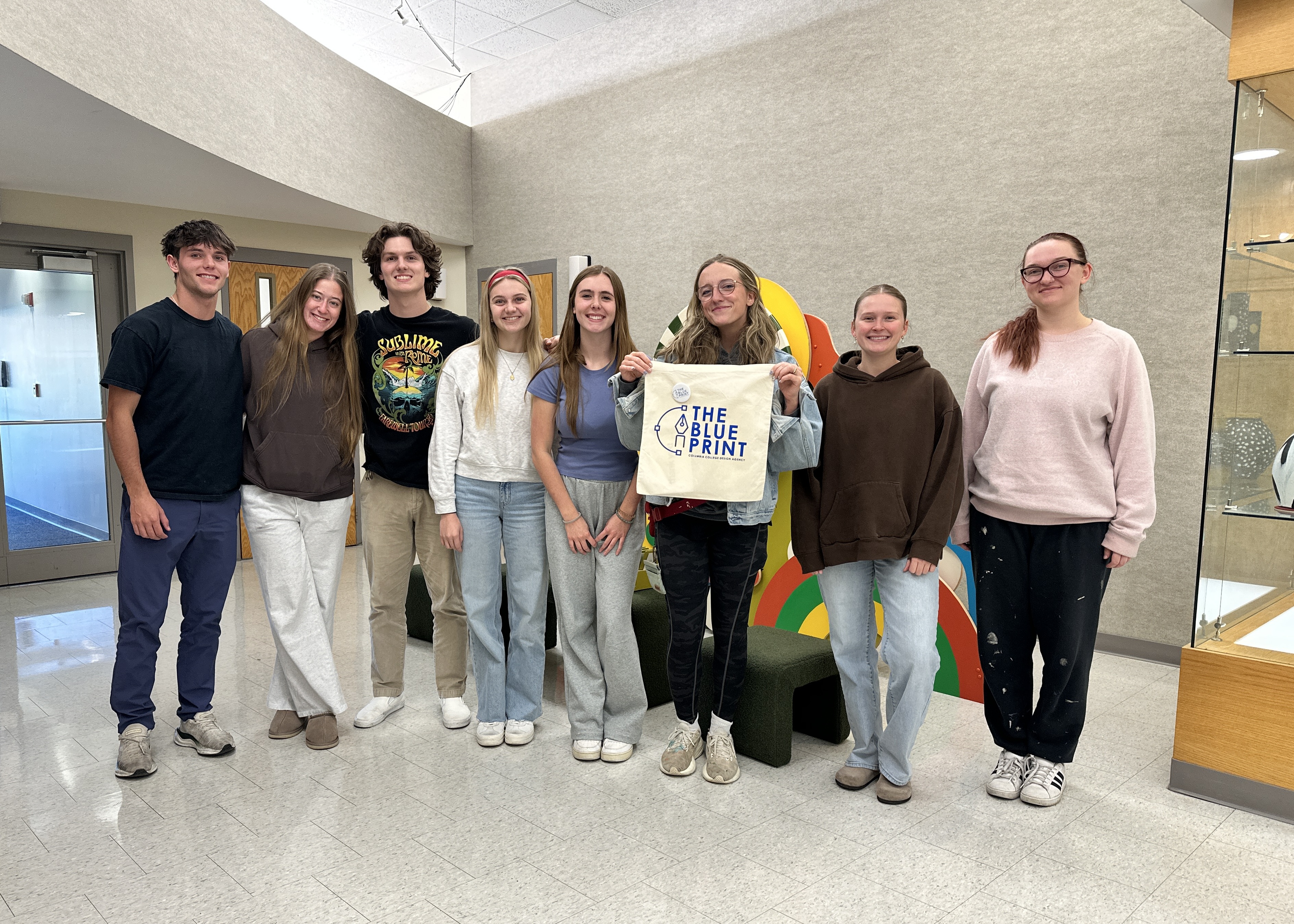 Eight students representing The Blue Print agency to celebrate collaboration with Cafe Berlin.