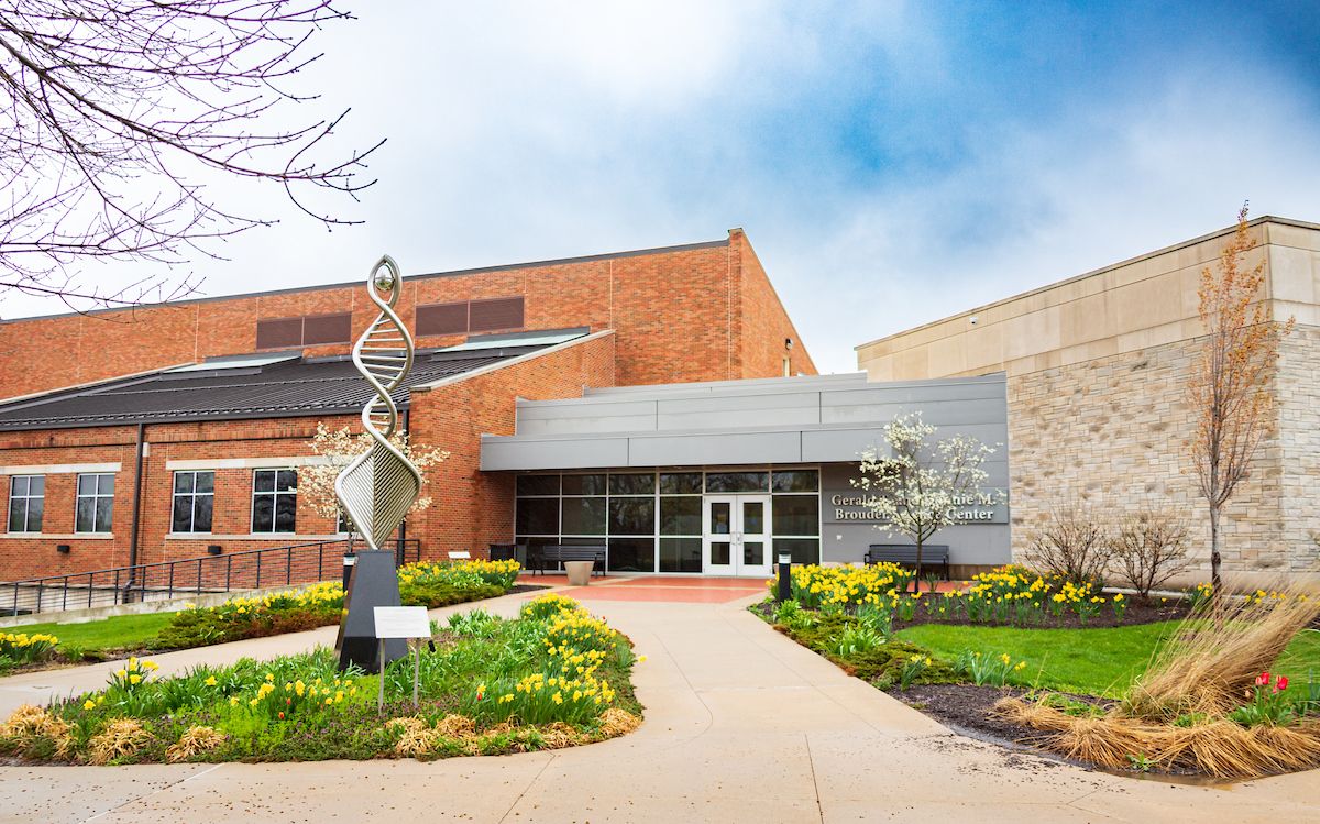 Widescreen of the Gerald Brouder Science Center entrance in spring, with yellow flowers blooming in the courtyard.