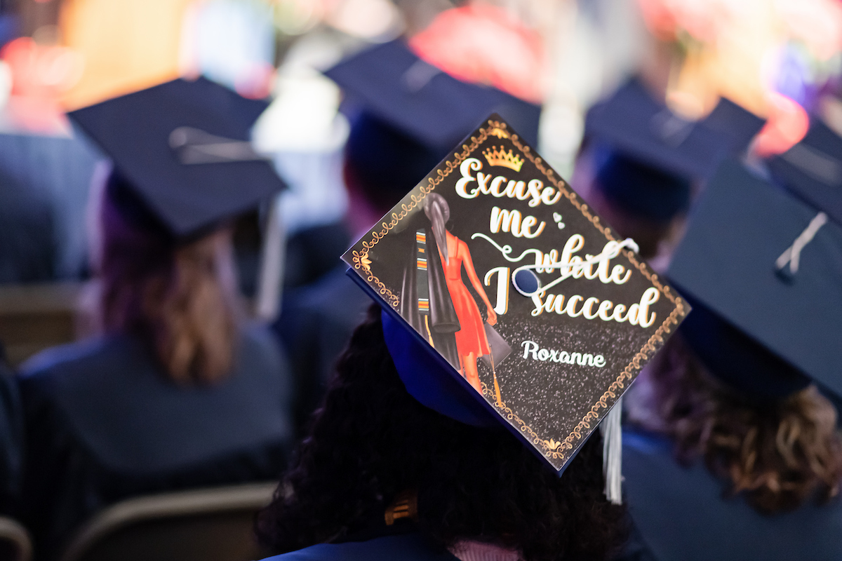 Picture of a decorated graduation cap that reads "Excuse me while I succedd".