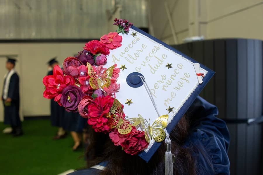 Commencement ceremony with mortarboard, translating to "Sometimes I cried, sometimes I doubted, but I never gave up.".
