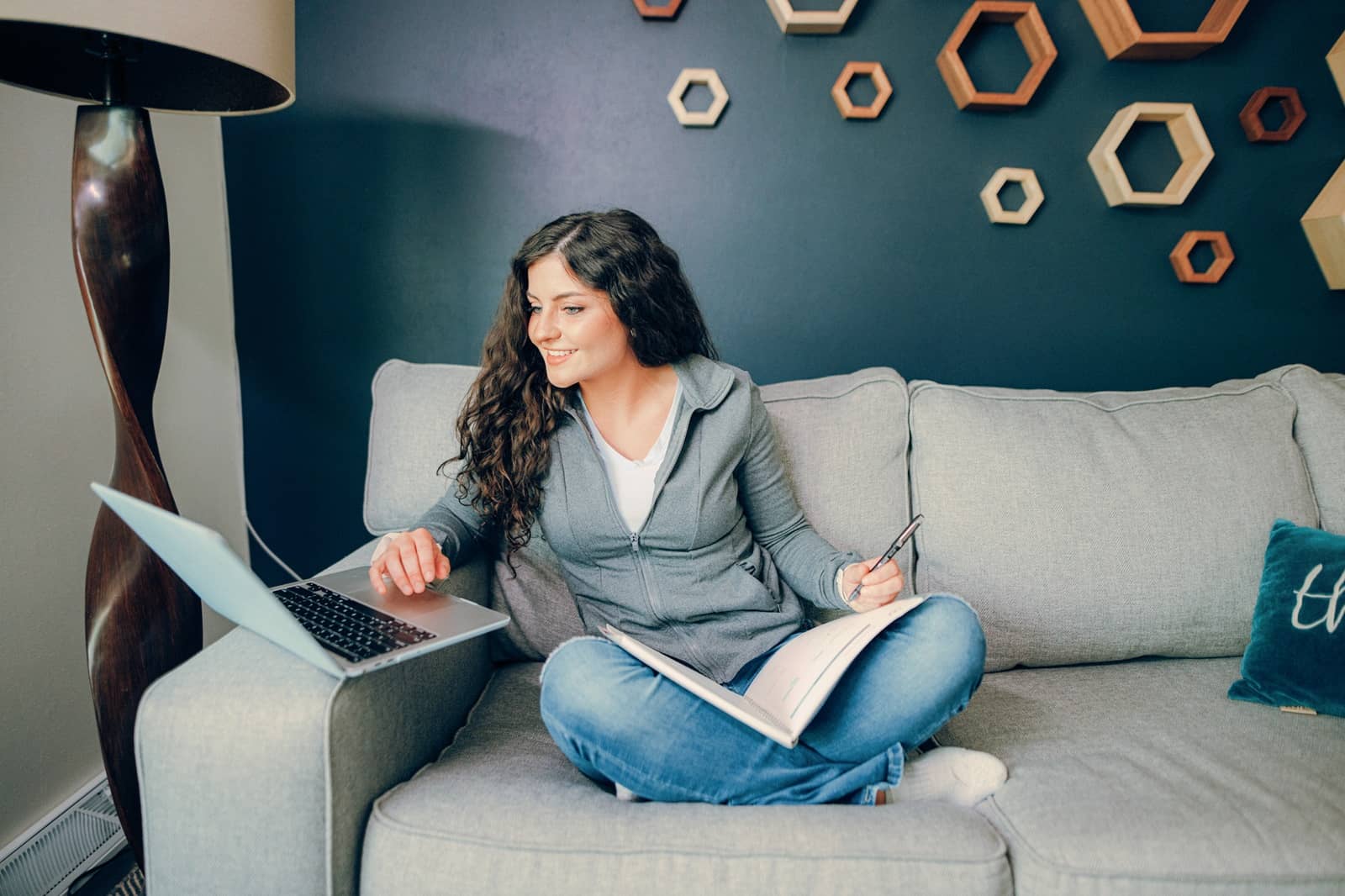 Online student, sitting on the couch with a laptop in front of her,.