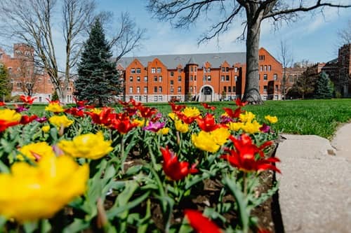 View of St. Clair Hall, with spring flowers in bloom, taken from Rogers Gate.