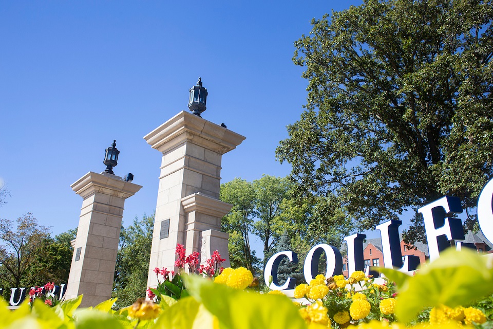 Ground level view of Rogers Gate, right side, with colorful flowers surrounding it.