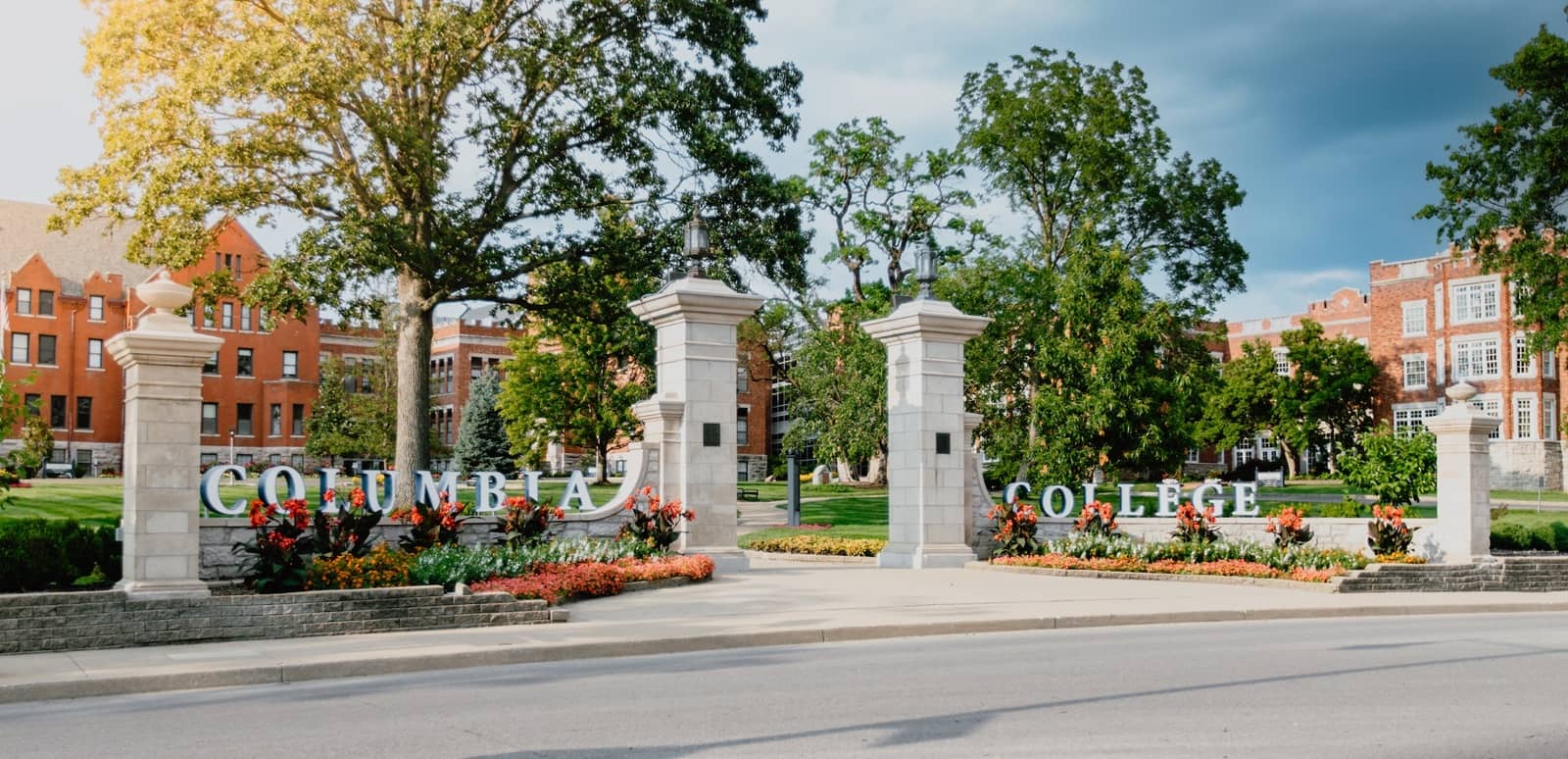 Rogers Gate entrance to Columbia College's main campus in the summer, with the gate surrounded by colorful flowers.